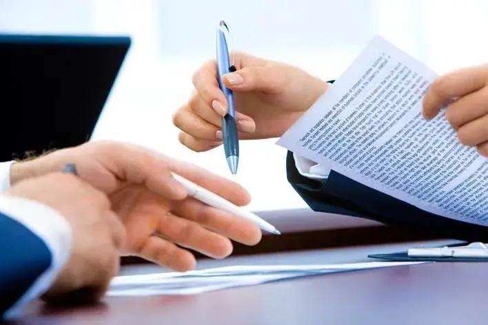 Dos personas firmando un acuerdo entre ellas