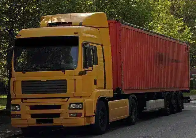 Camion naranja y amarillo en pleno transporte