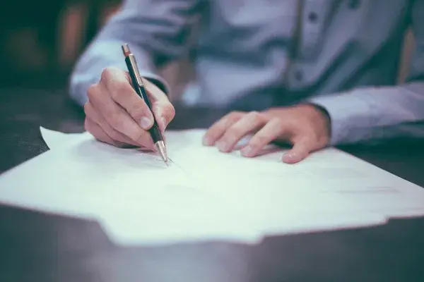 Una persona firmando unos documentos